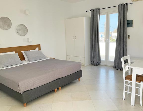 Διπλό κρεβάτι και τραπέζι φαγητού στα superior studios